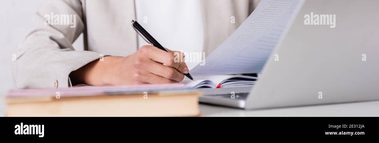 partial view of interpreter translating document on blurred foreground, banner Stock Photo