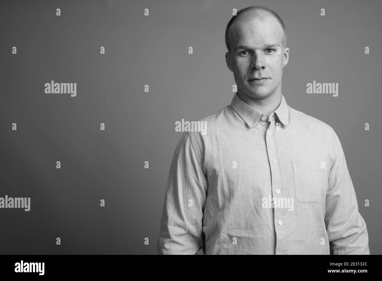 Bald businessman wearing blue shirt against gray background Stock Photo