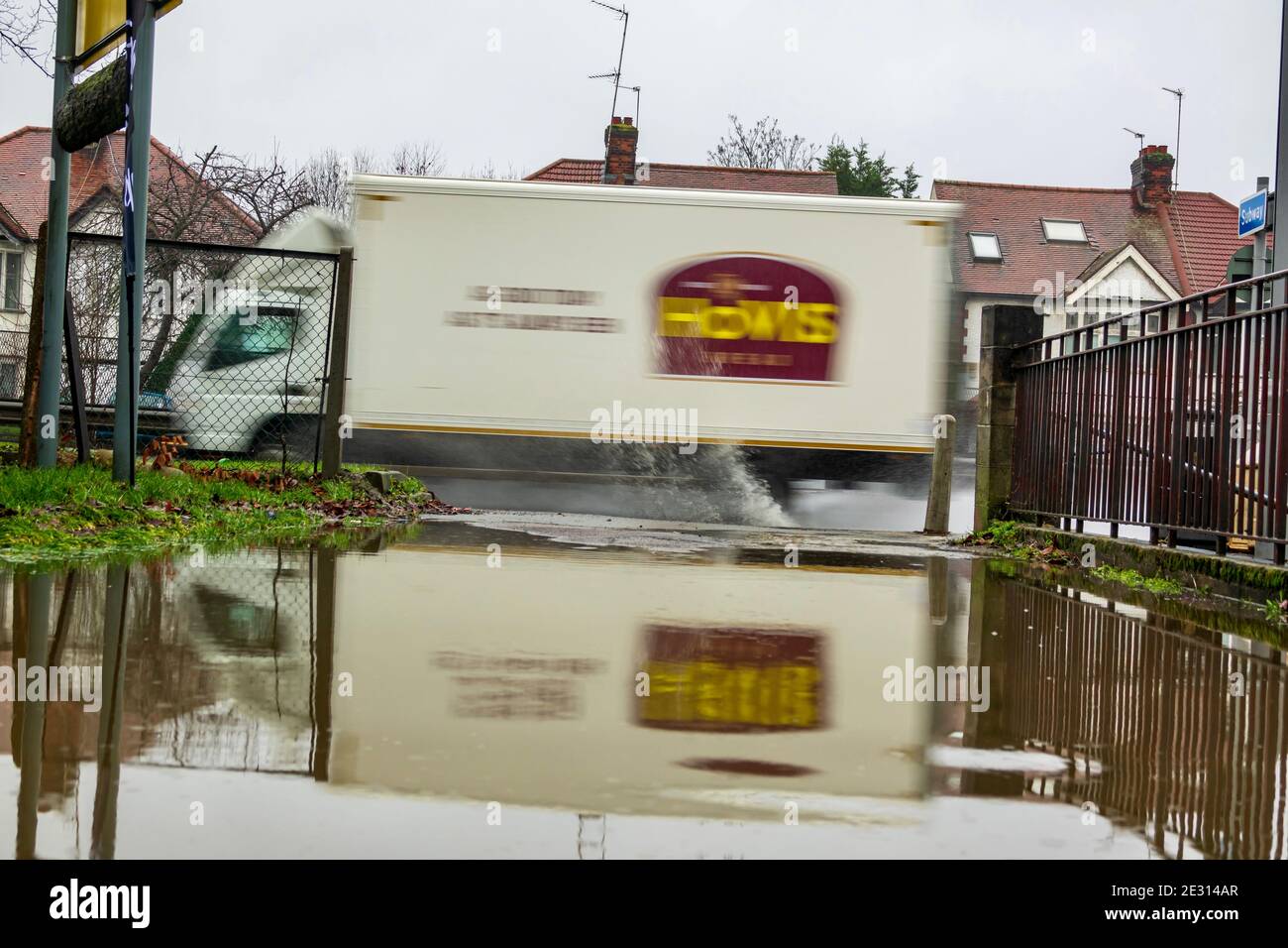 Hovis van drives along the A41 at speed splashing through a puddle during localised flooding from heavy rainfall. Stock Photo