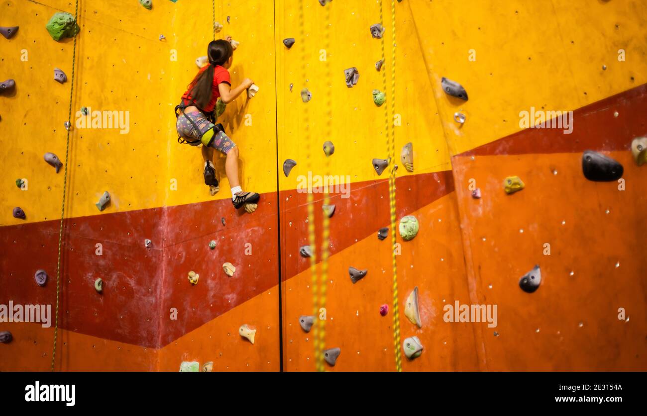 Little Girl Climbing Rock Wall Stock Photo - Alamy