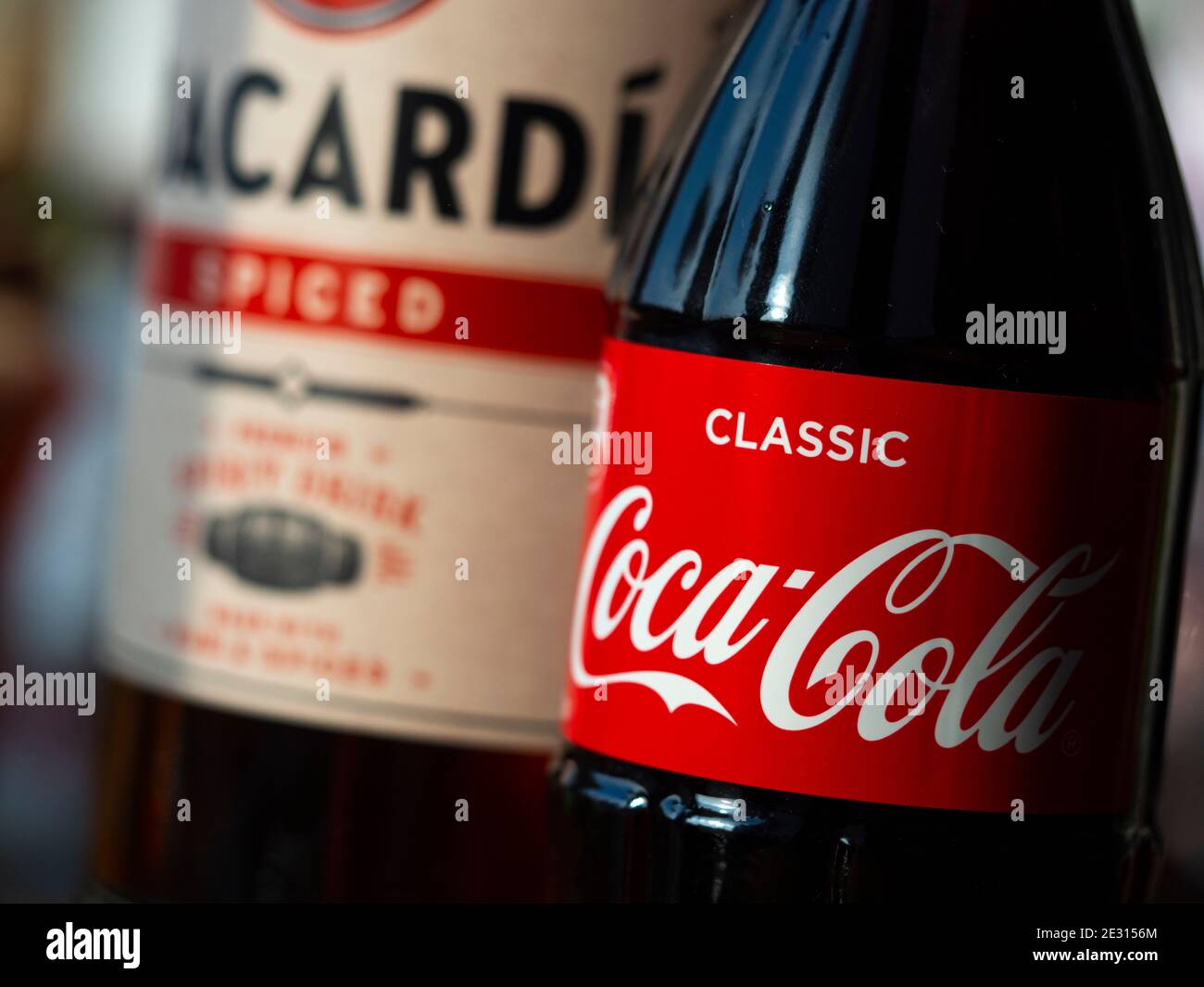In this photo illustration seen glass bottle of Coca-Cola and Bacardi spiced rum Stock Photo