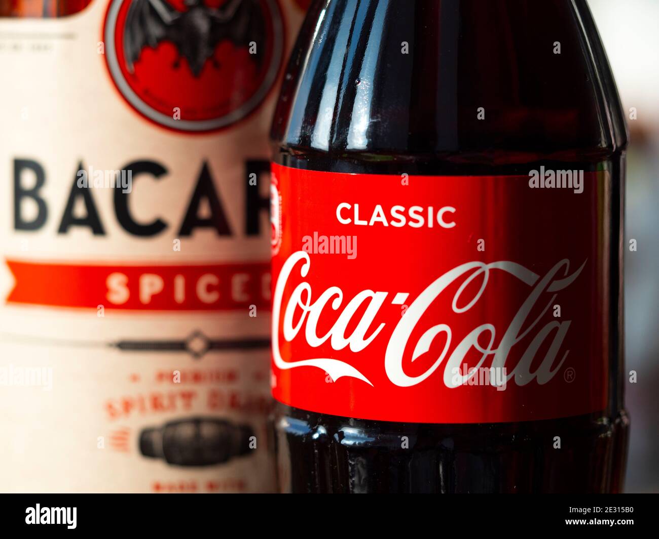 In this photo illustration seen glass bottle of Coca-Cola and Bacardi spiced rum Stock Photo