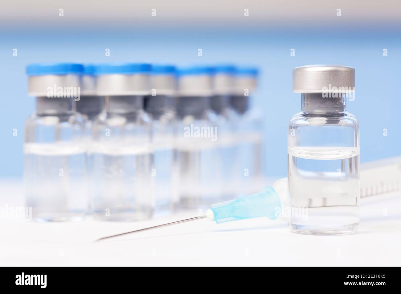 Vials and syringe with vaccine against covid-19 - focus on the vial in the foreground Stock Photo