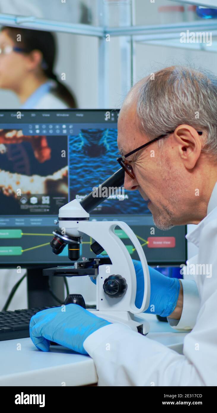 Medical research scientist conducting DNA experiments under microscope