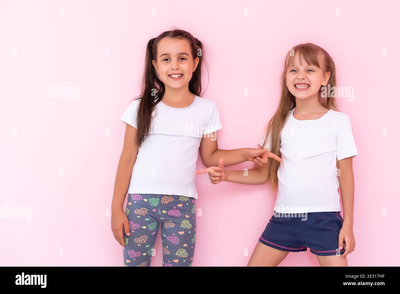 Two Little Girls Best Friends Isolated Over On A Pink Background Stock Photo Alamy