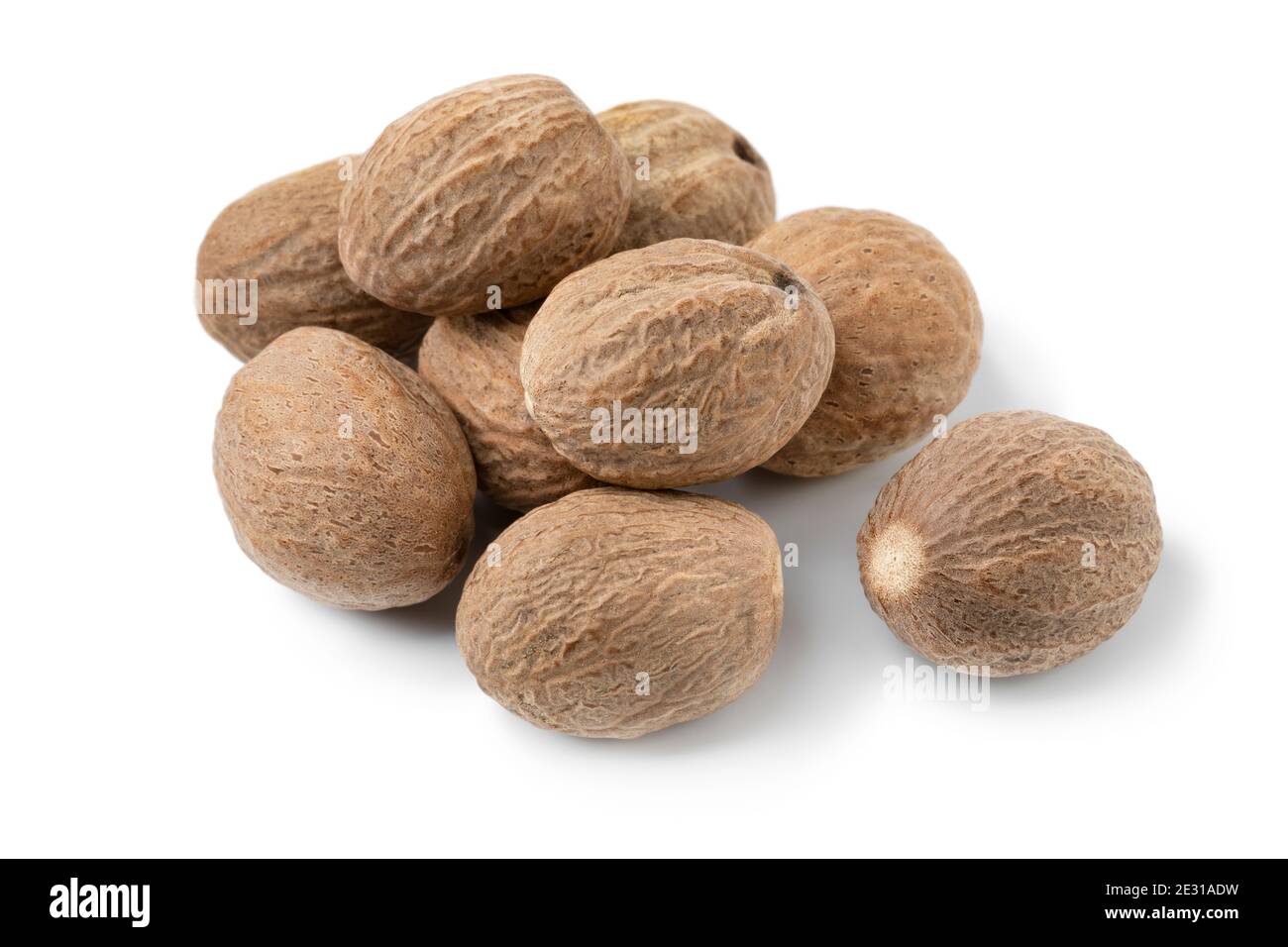 Heap of whole dried nutmeg seeds close up isolated on white background ...