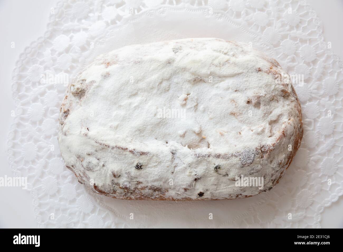 Christstollen Christmas stollen cake isolated on white. Sweet german traditional bread with raisins, nuts, spices, dried fruits and icing sugar, top v Stock Photo