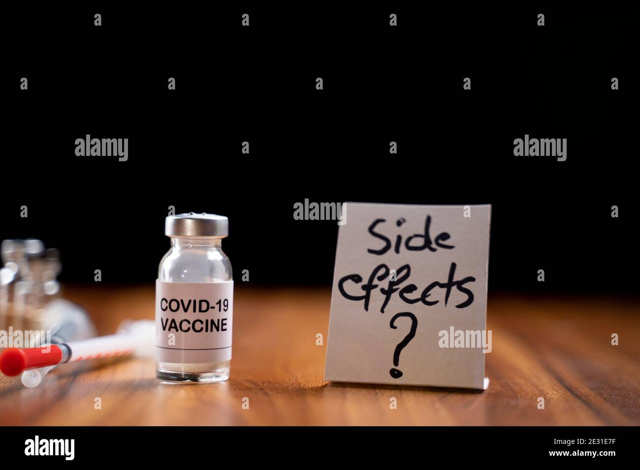 Concept of Coronavirus covid-19 vaccination side effects doubts and questions showing with vaccine bottle Stock Photo