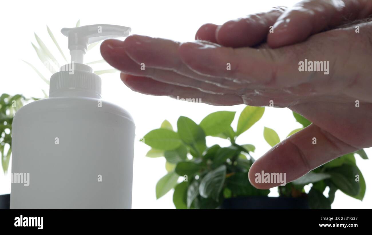 Man Cleans and Disinfects His Hands with Antibacterial Solution Stock