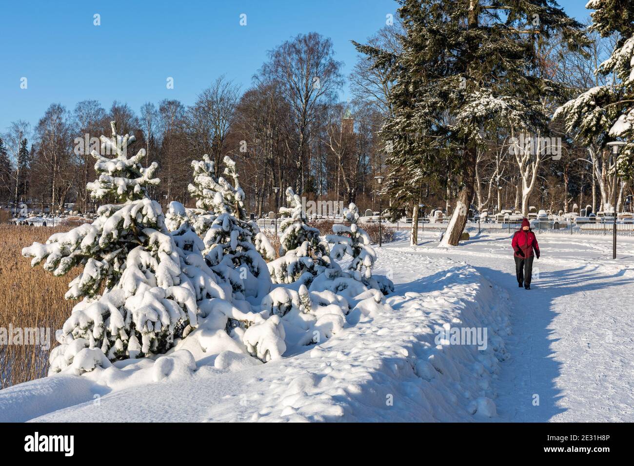 Middle-aged woman on a Saturday stroll by Lapinlahti Bay on a sunny winter day in Helsinki, Finland Stock Photo