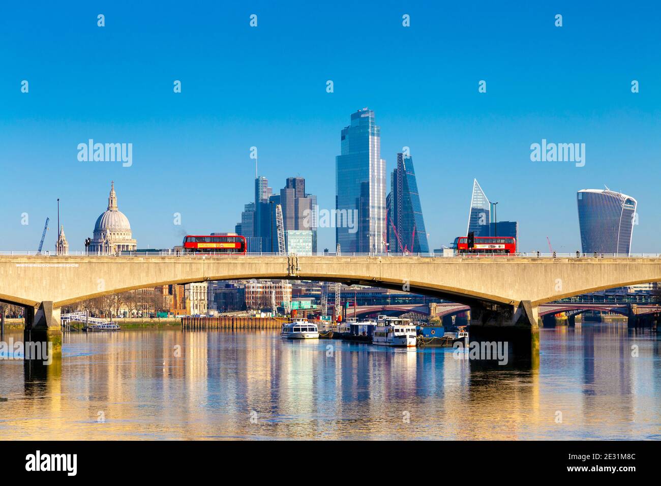 Red double decker buses crossing the Waterloo Bridge over the Thames river, London, UK Stock Photo