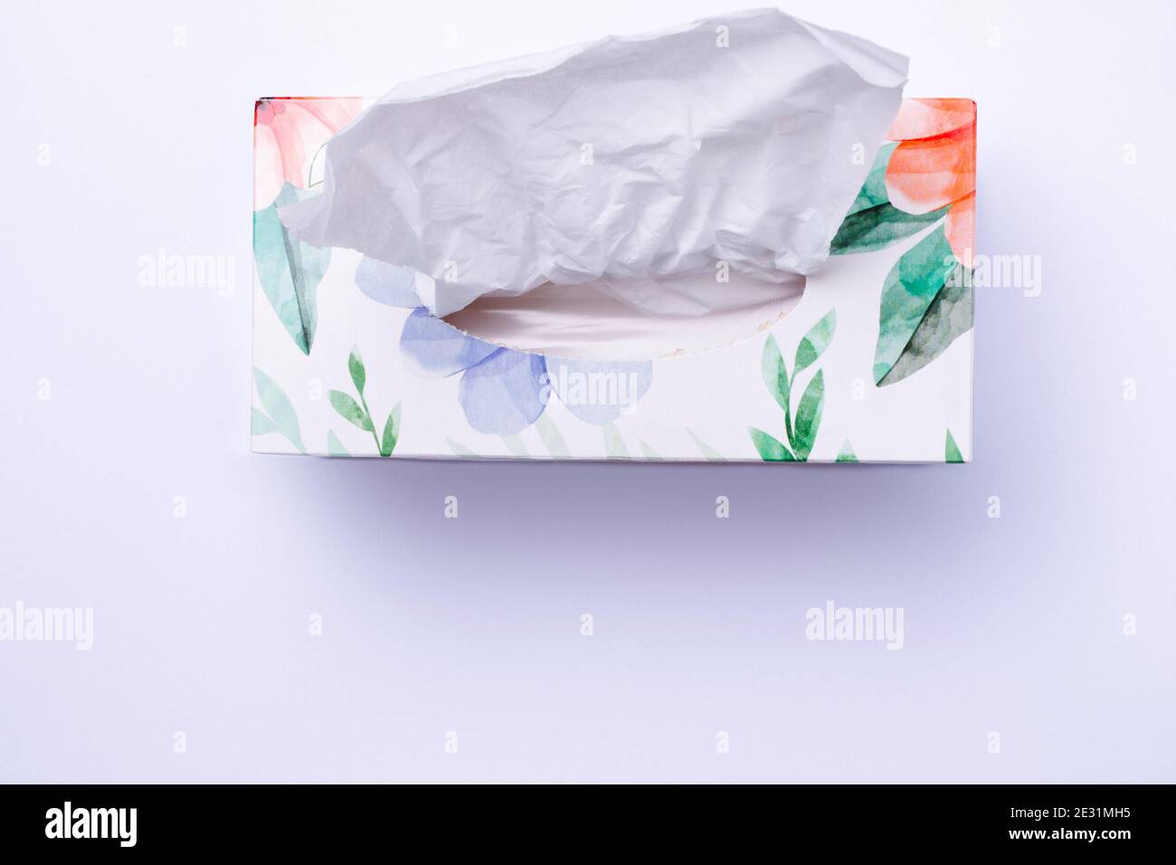 Colored box with disposable paper napkins on white background with bottom blank space. Stock Photo