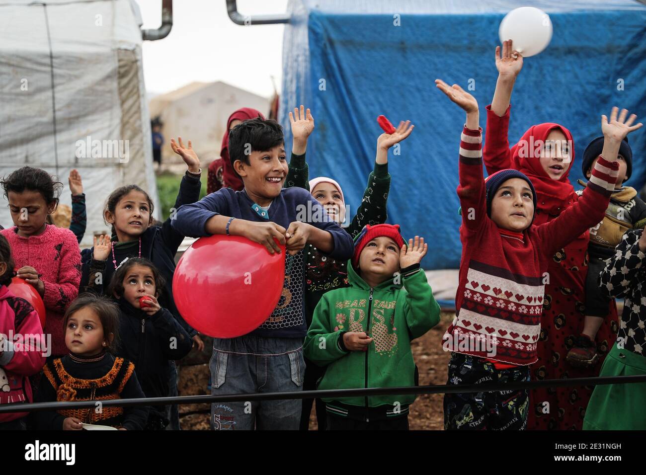 Sarmada, Syria. 16th Jan, 2021. Syrian children cheer for competitors taking part in a sports competition organized by volunteers at the Baraem camp for internally displaced people. Credit: Anas Alkharboutli/dpa/Alamy Live News Stock Photo