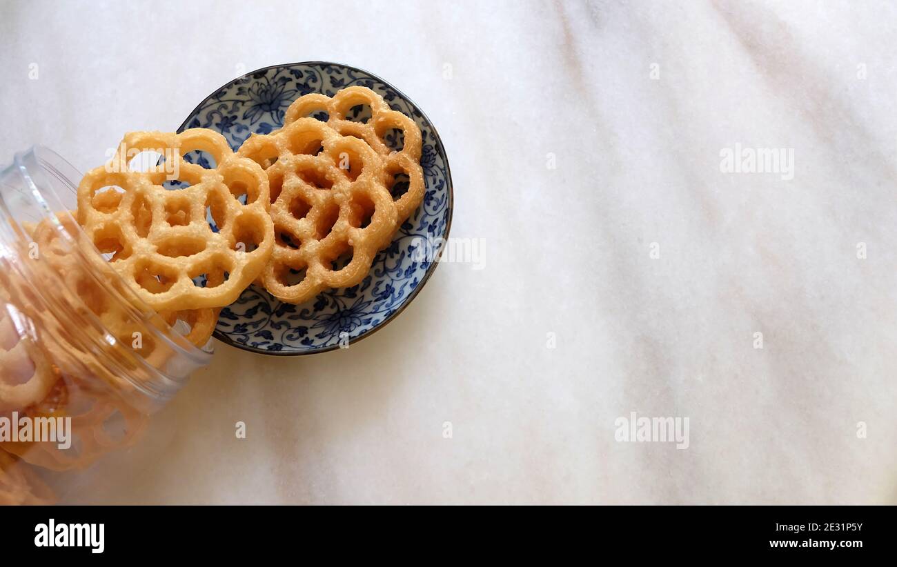 Honeycomb cookies pouring out. Also known as kuih loyang in Malaysia, a popular deep-fried sweet snack during festivals. Stock Photo