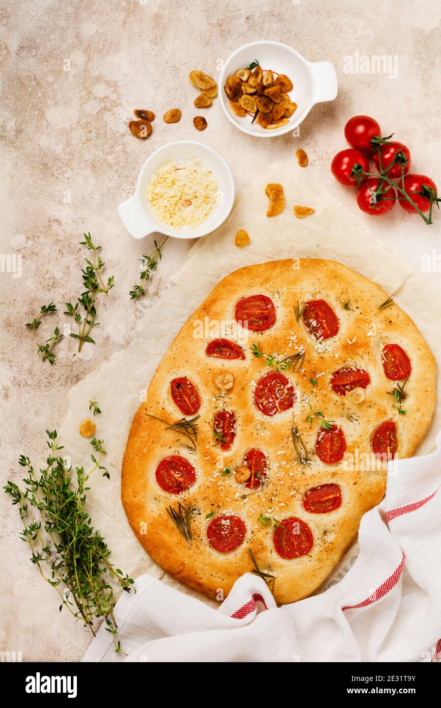 Italian traditional focaccia bread baking with with cherry tomatoes ...