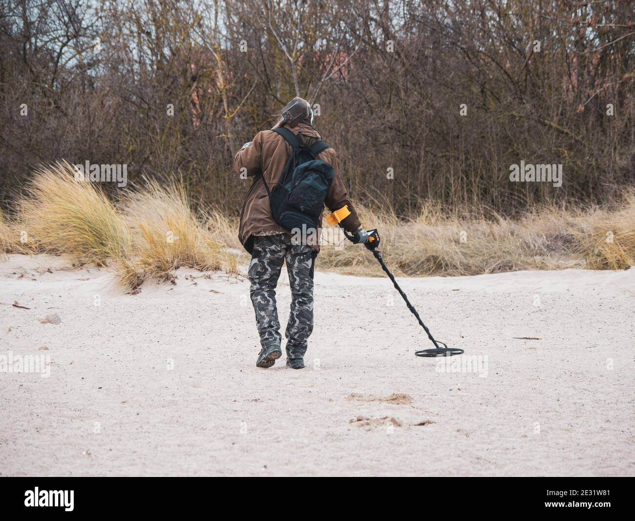 a man searches the beach with a metal detector Stock Photo Alamy