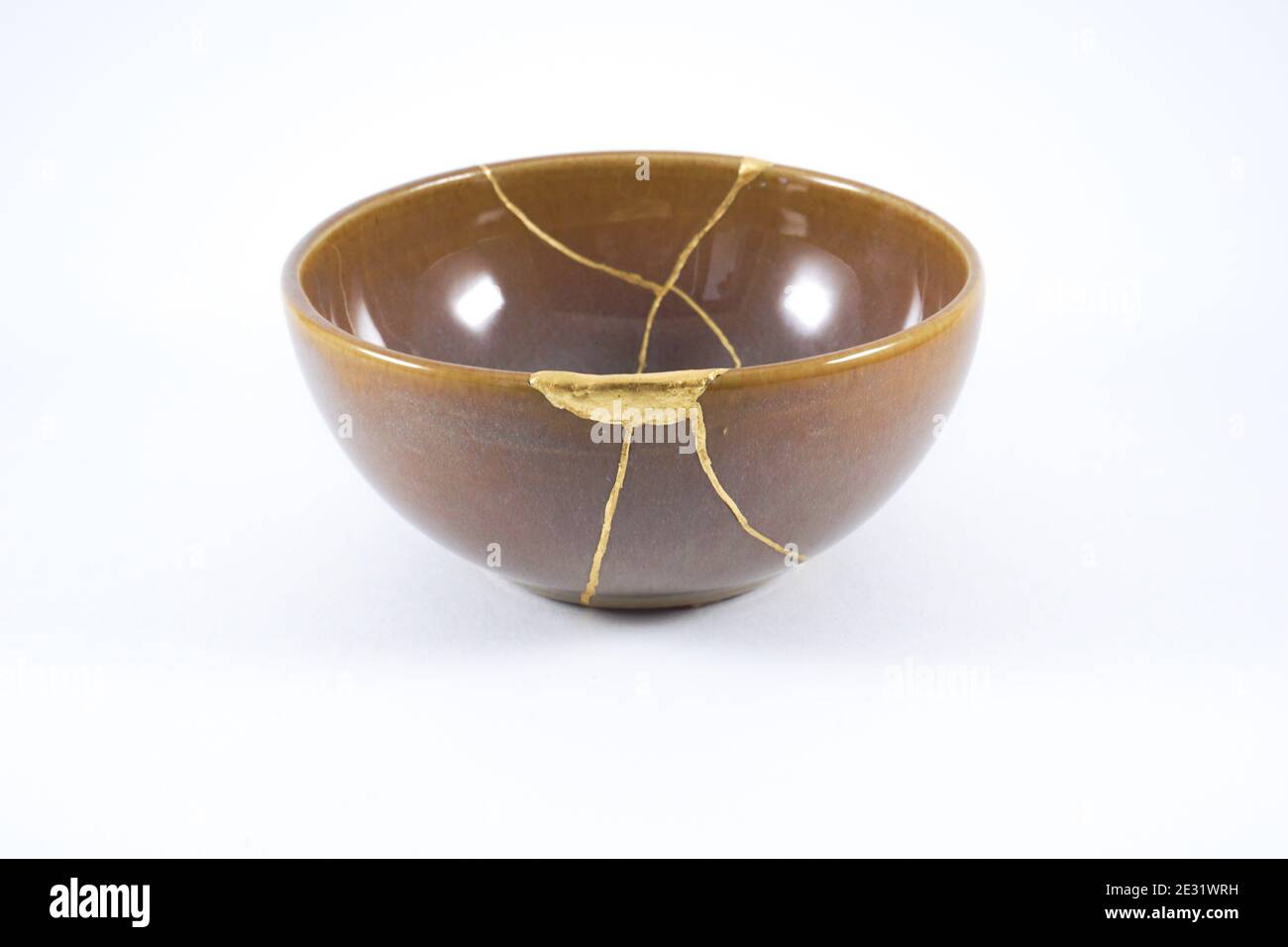 Japanese Kintsugi brown bowl restored with gold Stock Photo