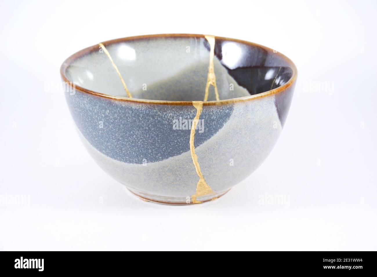 Kintsugi bowl, real gold restoration on grey pottery Stock Photo
