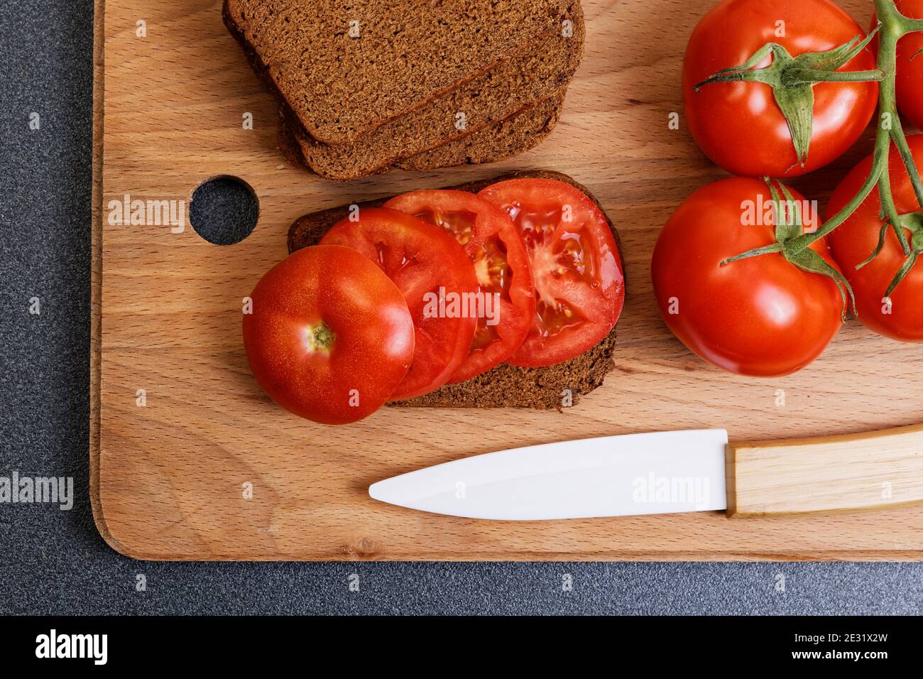 Top view of fresh tomato and bread on the kitchen cutting board Stock ...