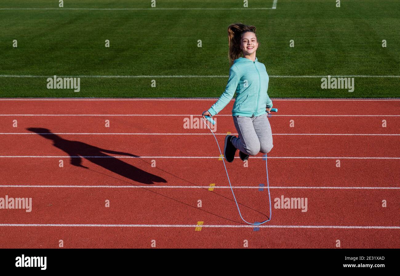 a workout routine. kid in sportswear jump on skipping rope. child do ...