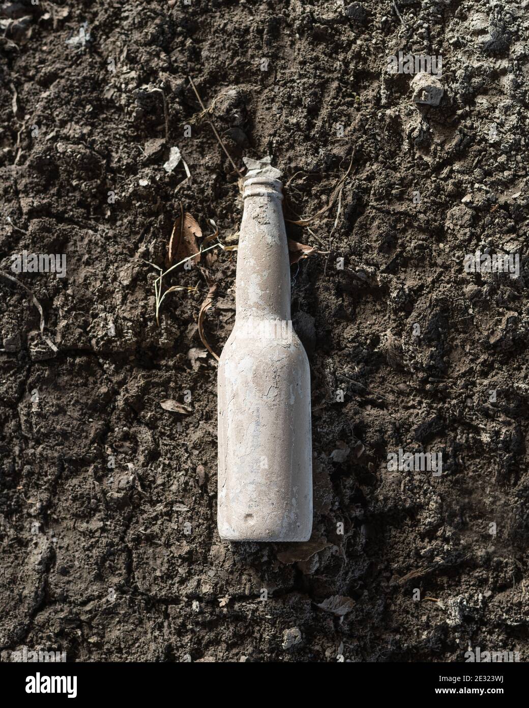 Dirty bottle isolated on muddy background Stock Photo