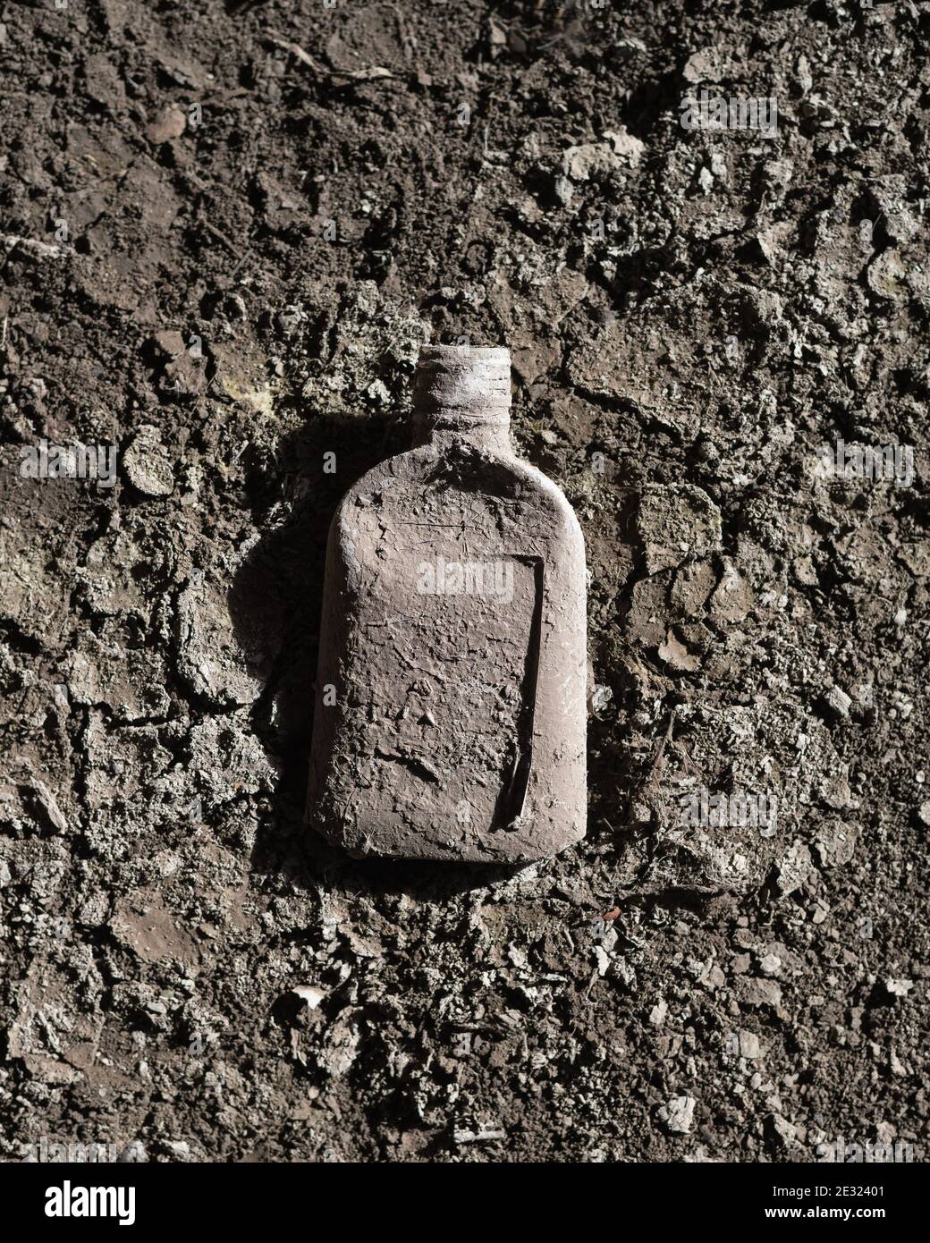 Dirty bottle isolated on muddy background Stock Photo
