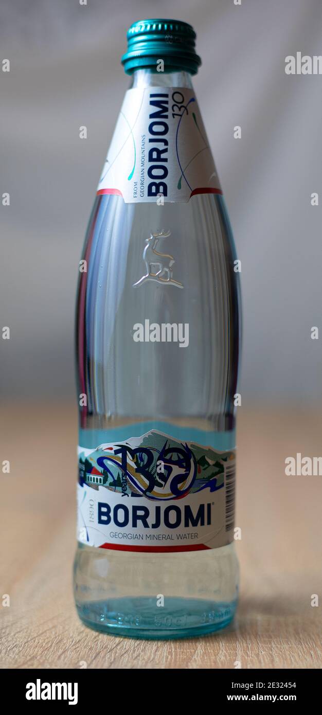Glass bottle of Borjomi sparkling Georgian mineral water on wooden table. Borjomi is the most popular mineral water Stock Photo