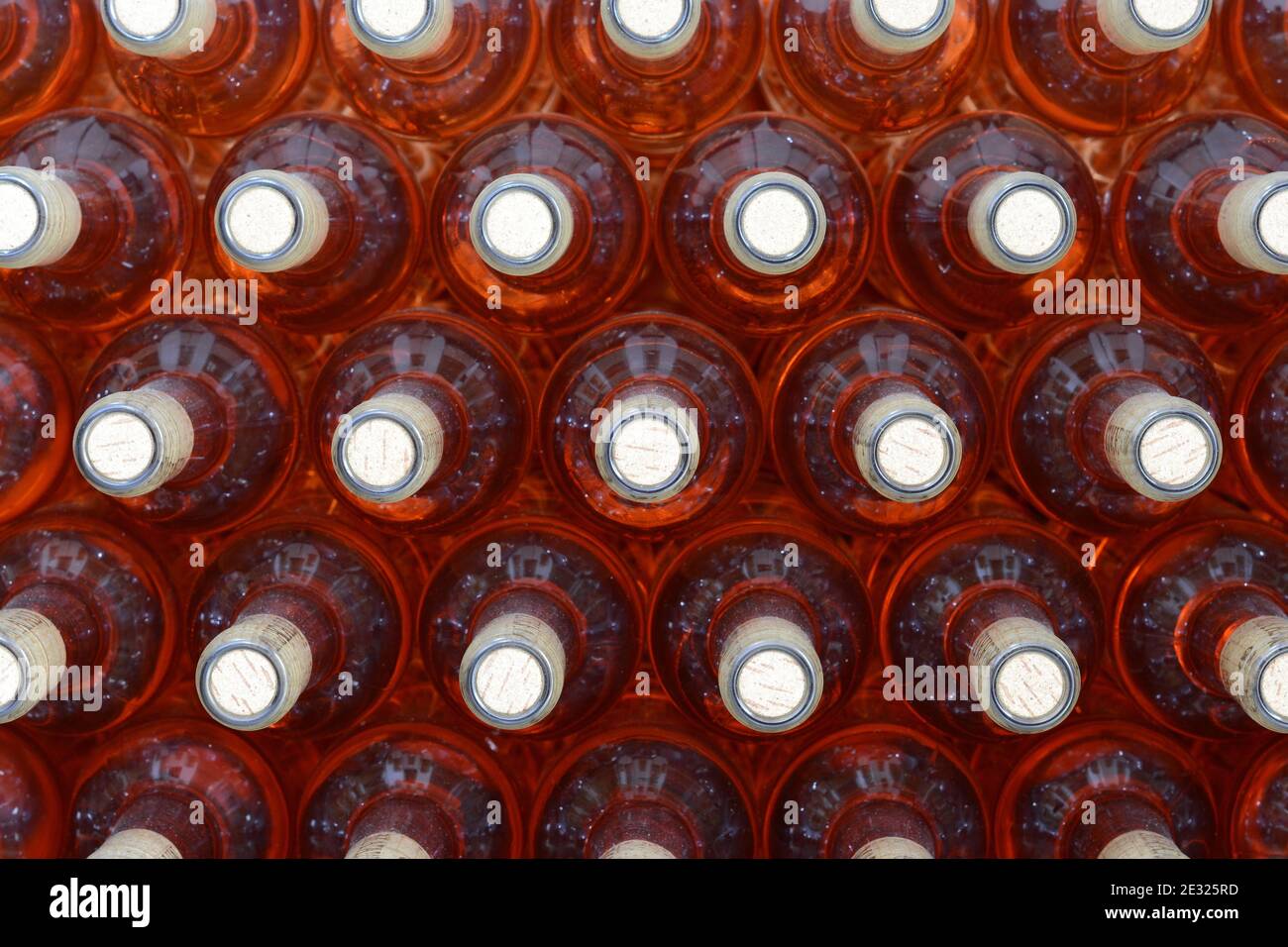 Full bottles of wine, stacked in a winery. Lot of bottles Stock Photo