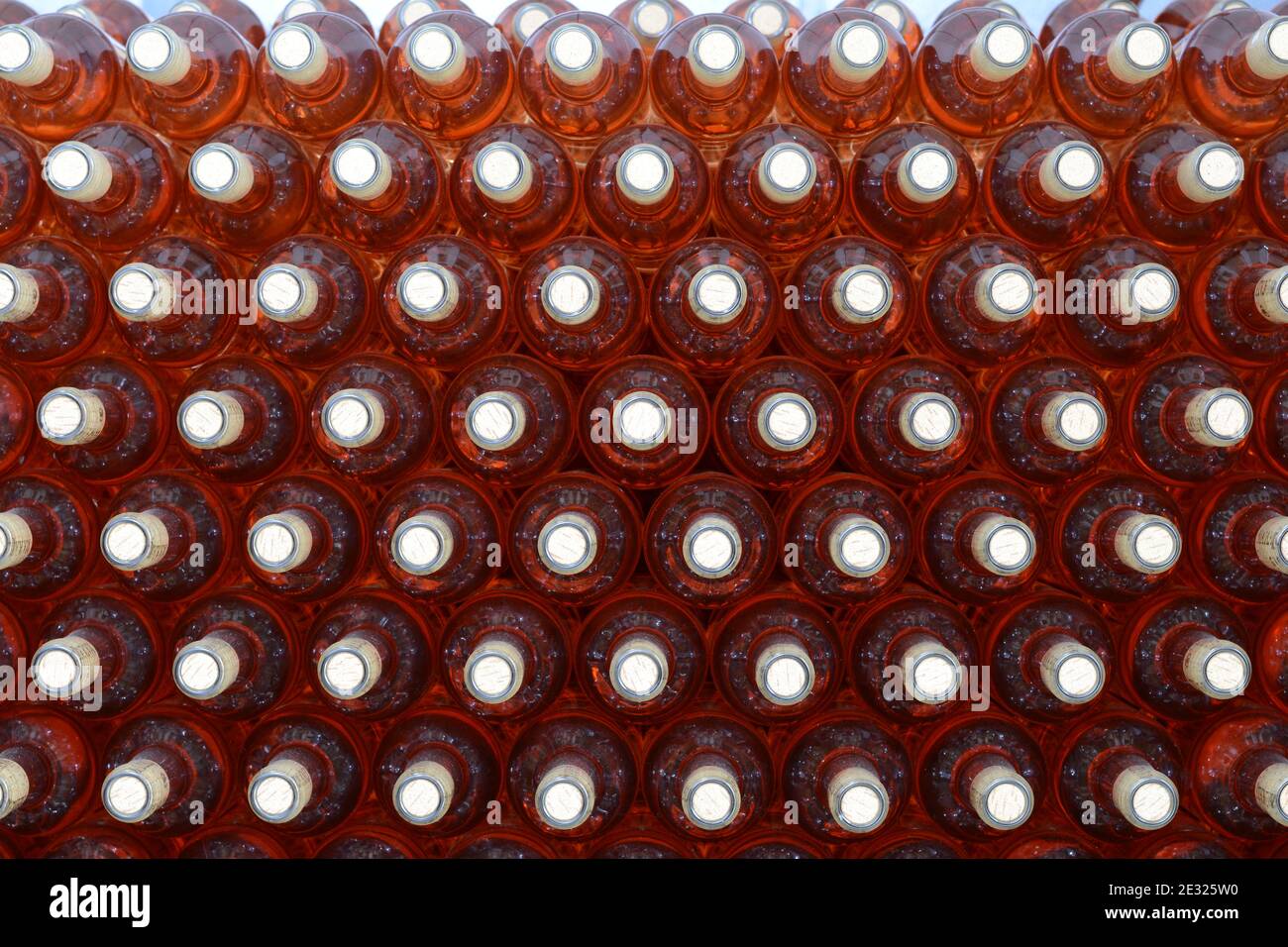 Full bottles of wine, stacked in a winery. Lot of bottles Stock Photo