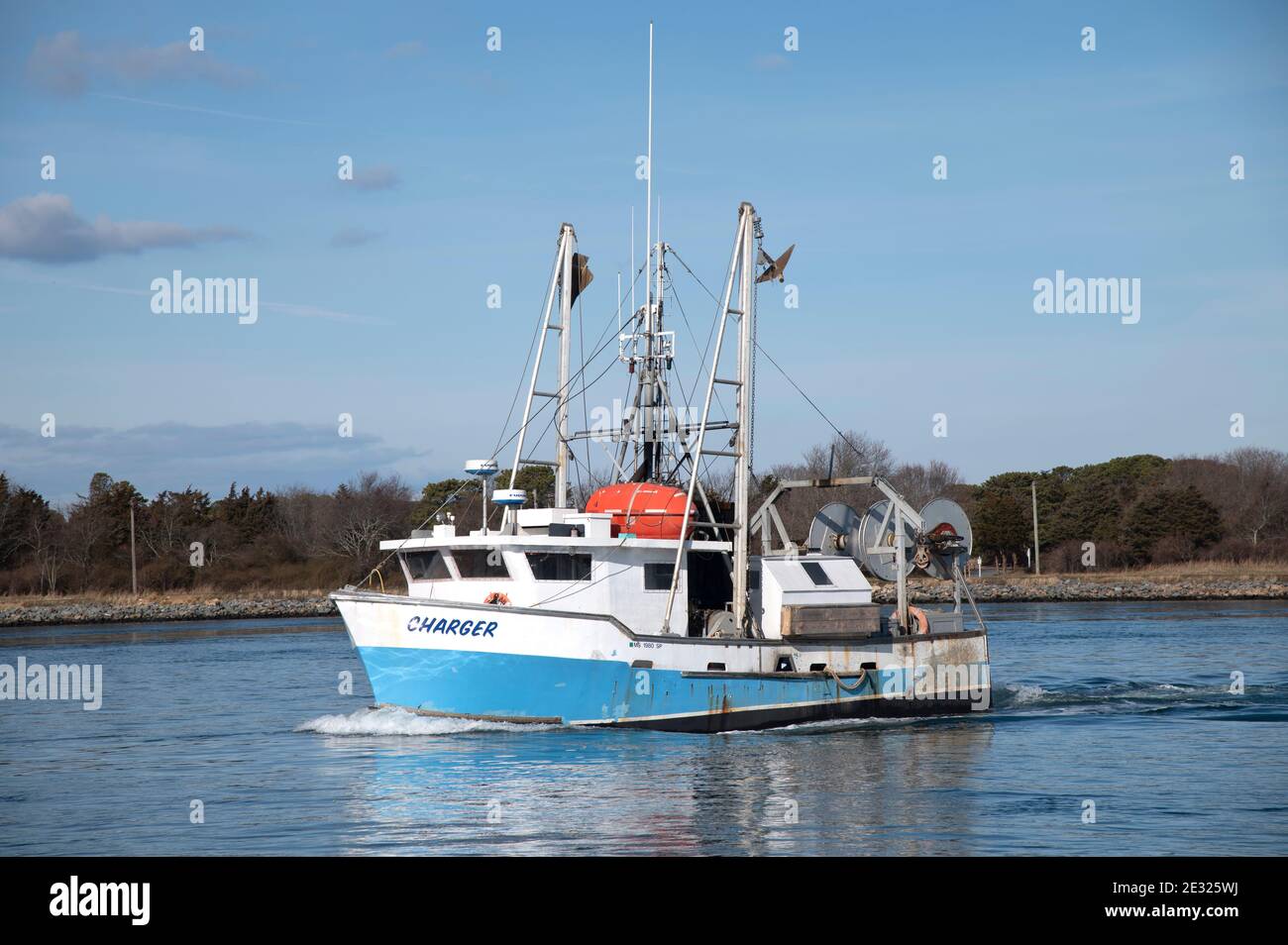 A fishing trawler passing through the Cape Cod Canal in Sandwich, Massachusetts. Stock Photo