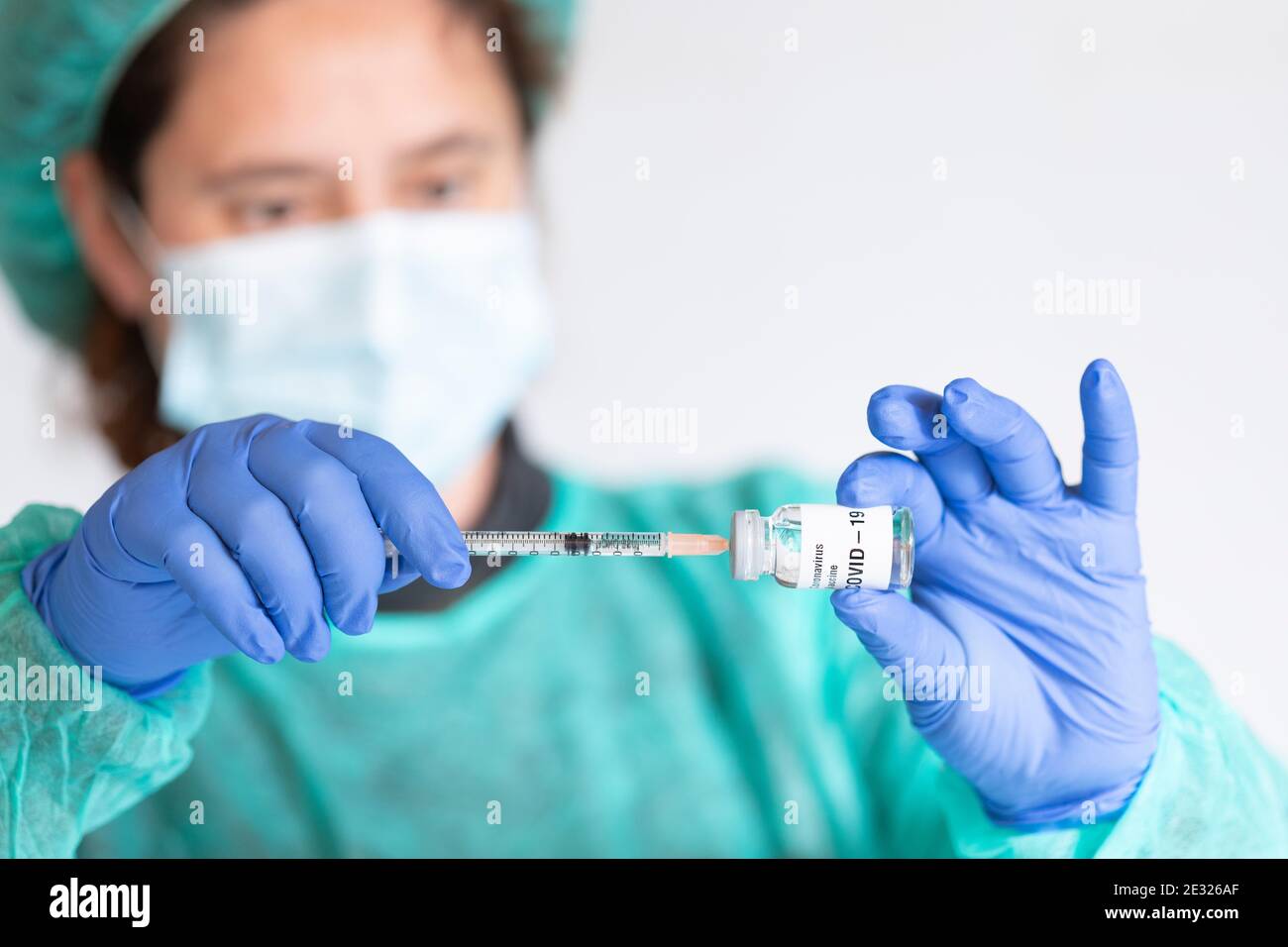 COVID-19 Coronavirus Vaccine. Doctor scientist with syringe analyzing virus Sars-CoV-2 in research for vaccine to be ready for clinical trial. Female Stock Photo