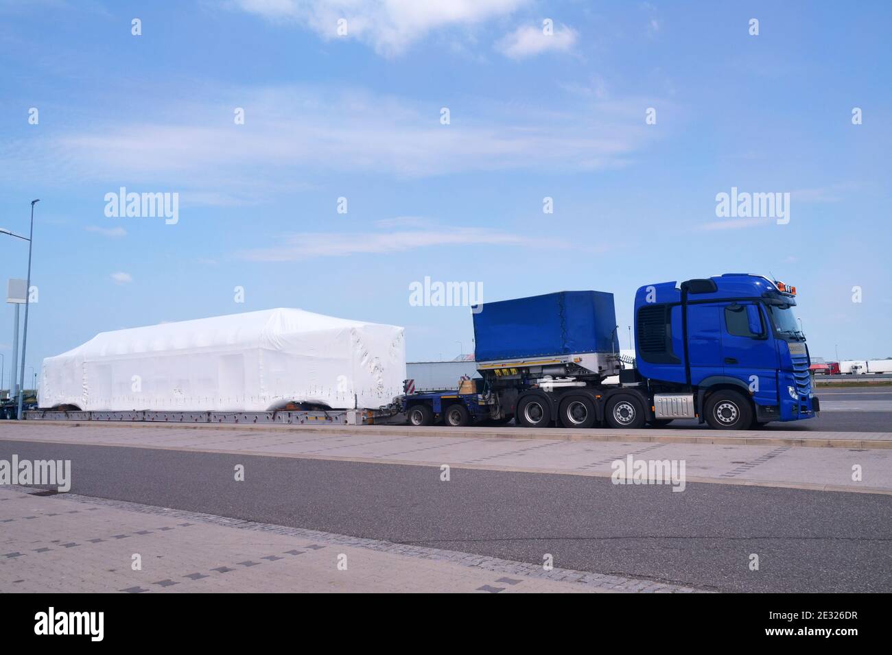 A very long and heavy load on a specialized semi-trailer. Long vehicle. Over-standard, atypical road transport. Exceptional convoy. Stock Photo