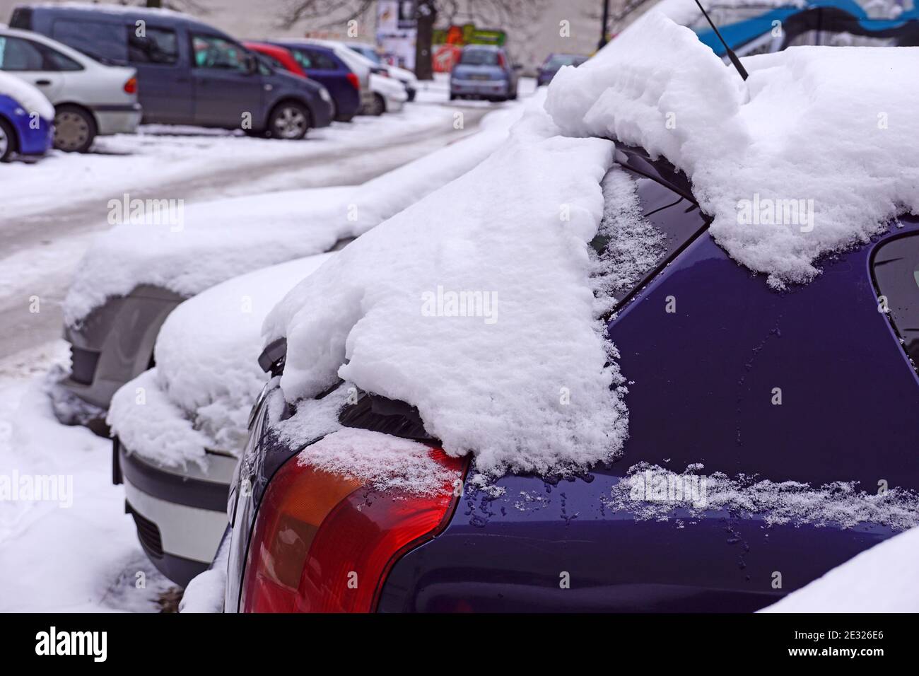 Cars covered with a thick layer of frozen snow. The estate car park in winter. Stock Photo