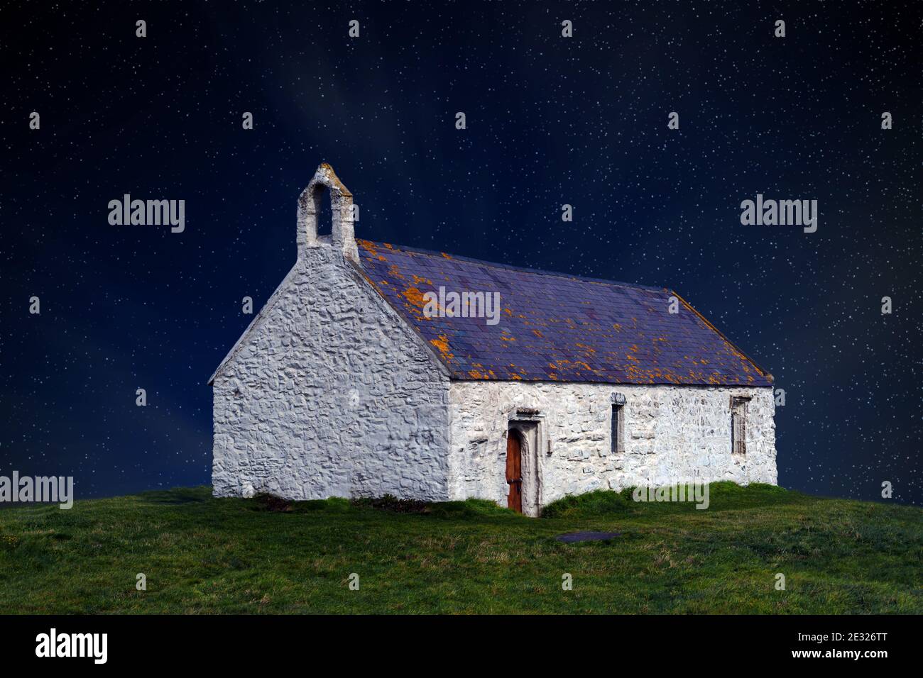St Cwyfan's is a 12 century church on the  tidal island of Cribinau, Anglesey. In this fantasy image the night sky has been added. Stock Photo
