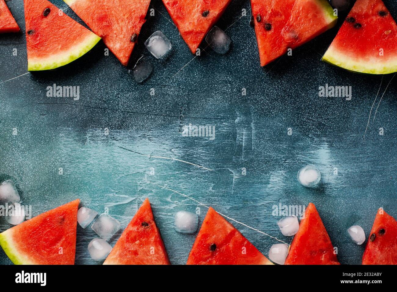 Slices of fresh watermelon with ice on a blue concrete background ...