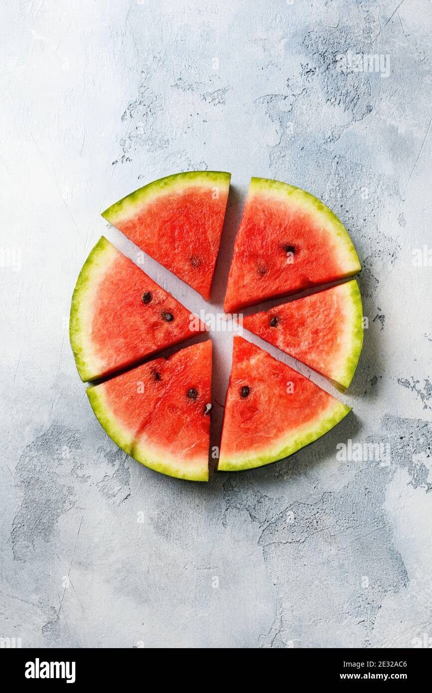 Slices of fresh watermelon with ice on a blue concrete background ...
