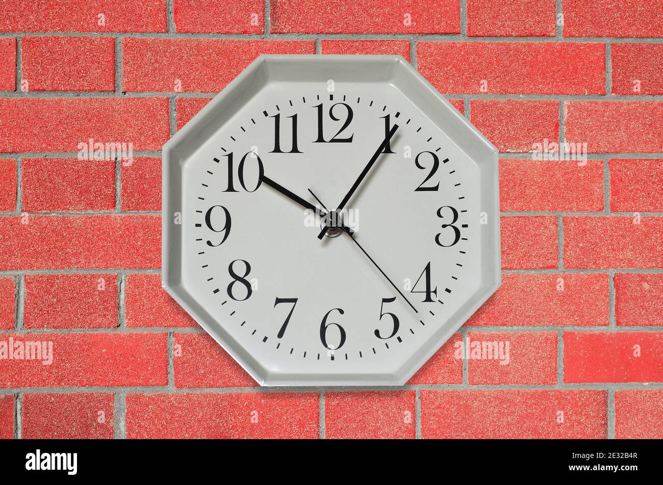 wall clock on a red brick wall Stock Photo