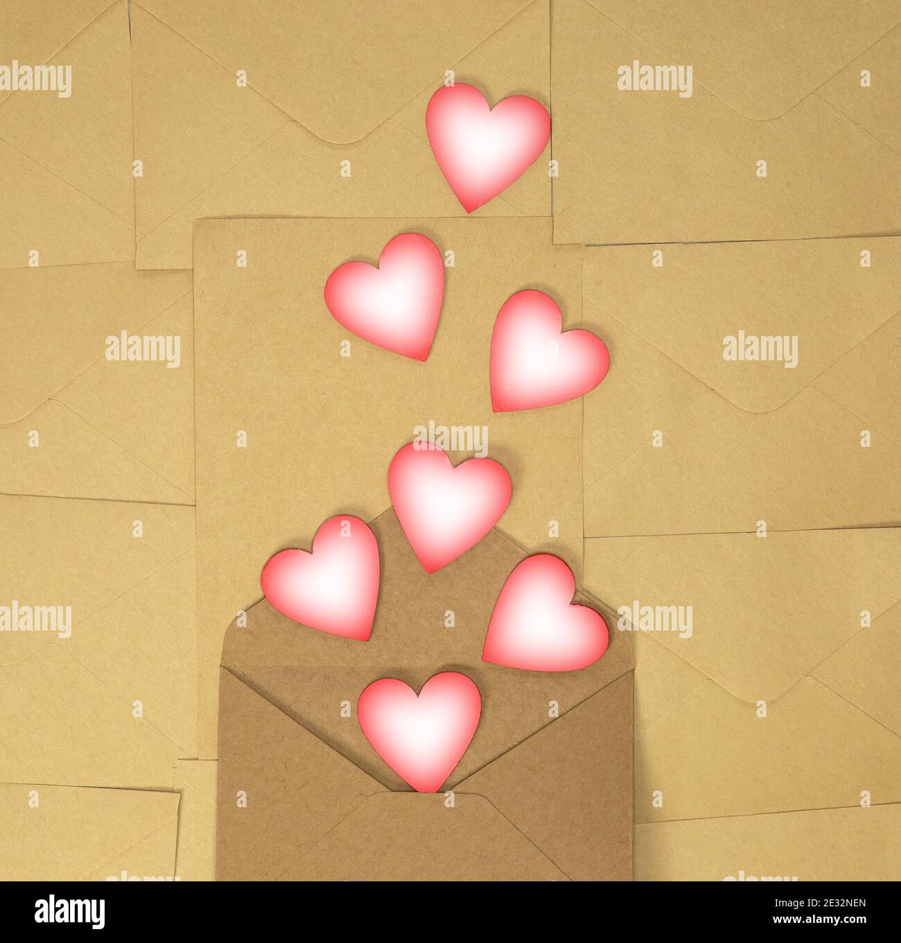 Paper craft envelope with pink hearts on brown plain background ...