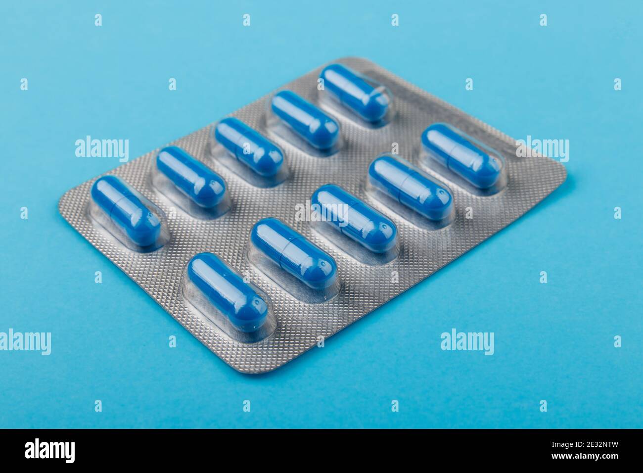 Pharmacy theme, blue pills in capsules, blue background, medicine. Stock Photo
