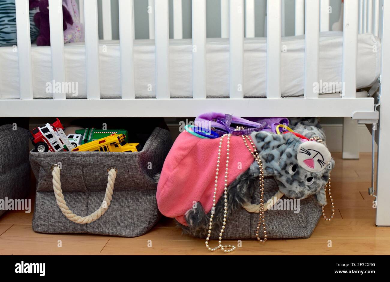 Toddler's toys and dress up clothes with easy bin storage under crib bed for simple clean up and modern lifestyle Stock Photo