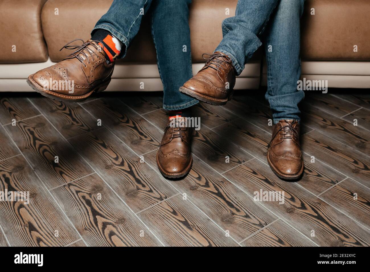 Legs of two men in the brown full grain leather shoes and funny socks.  Faceless man sitting on the sofa with crossed legs. Background Stock Photo  - Alamy
