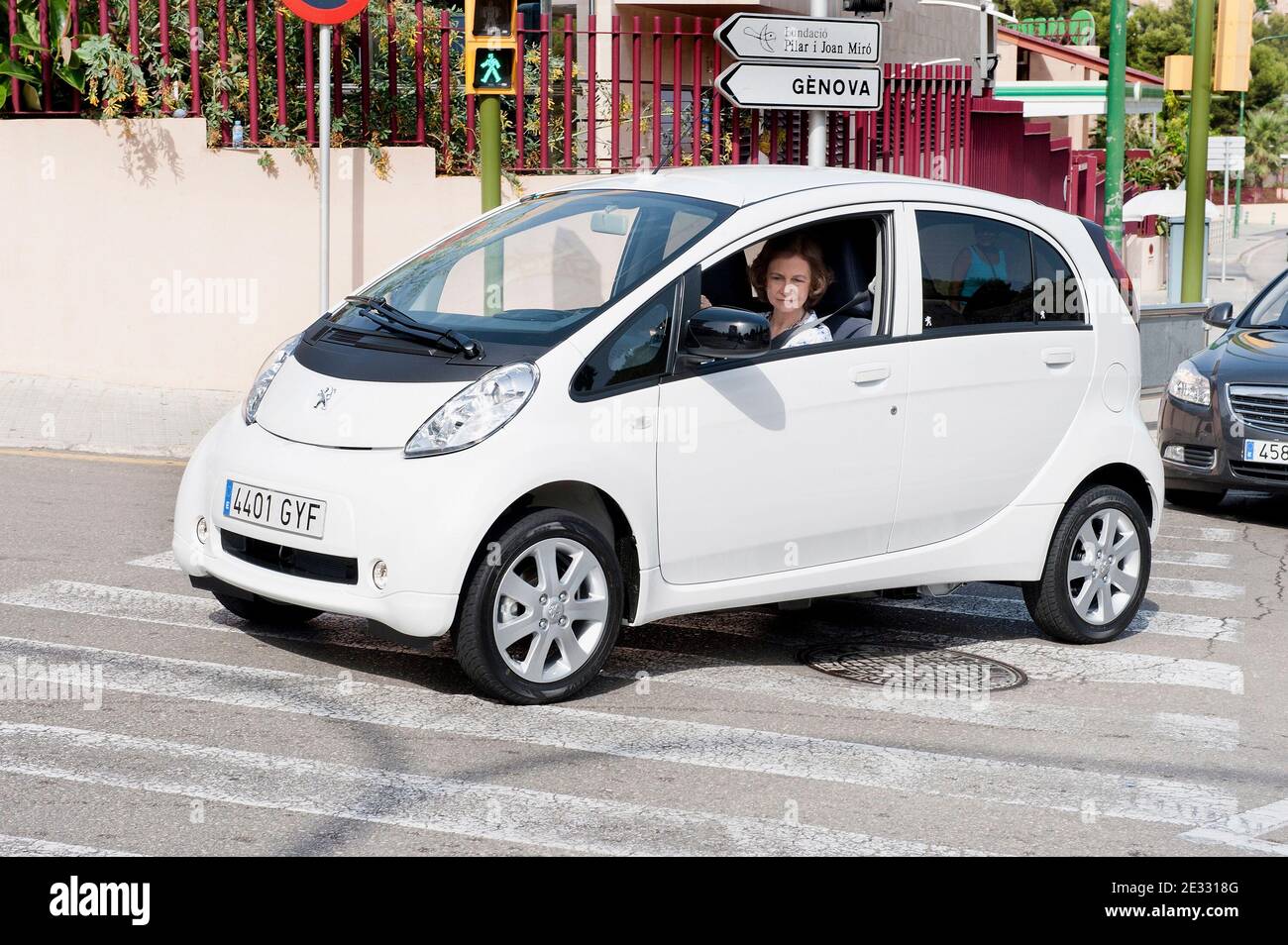 Spain's Queen Sofia drives a new electric car she just took delivery of, in Palma de Mallorca, Balearic Islands, Spain on August 11, 2010. The car, a Peugeot iON, has been lent to Queen SofÀa by the car company and was sent by air to Palma from Japan. The Queen will drive it for her private use for one month during her vacation at Marivent Palace on Mallorca. QueenæSofÀa has accepted the assignment as a show of support for electric cars as not pollutant vehicles respecting the environment. For security reasons the Queen was followed by two larger dark cars carrying her security detail. Photo b Stock Photo