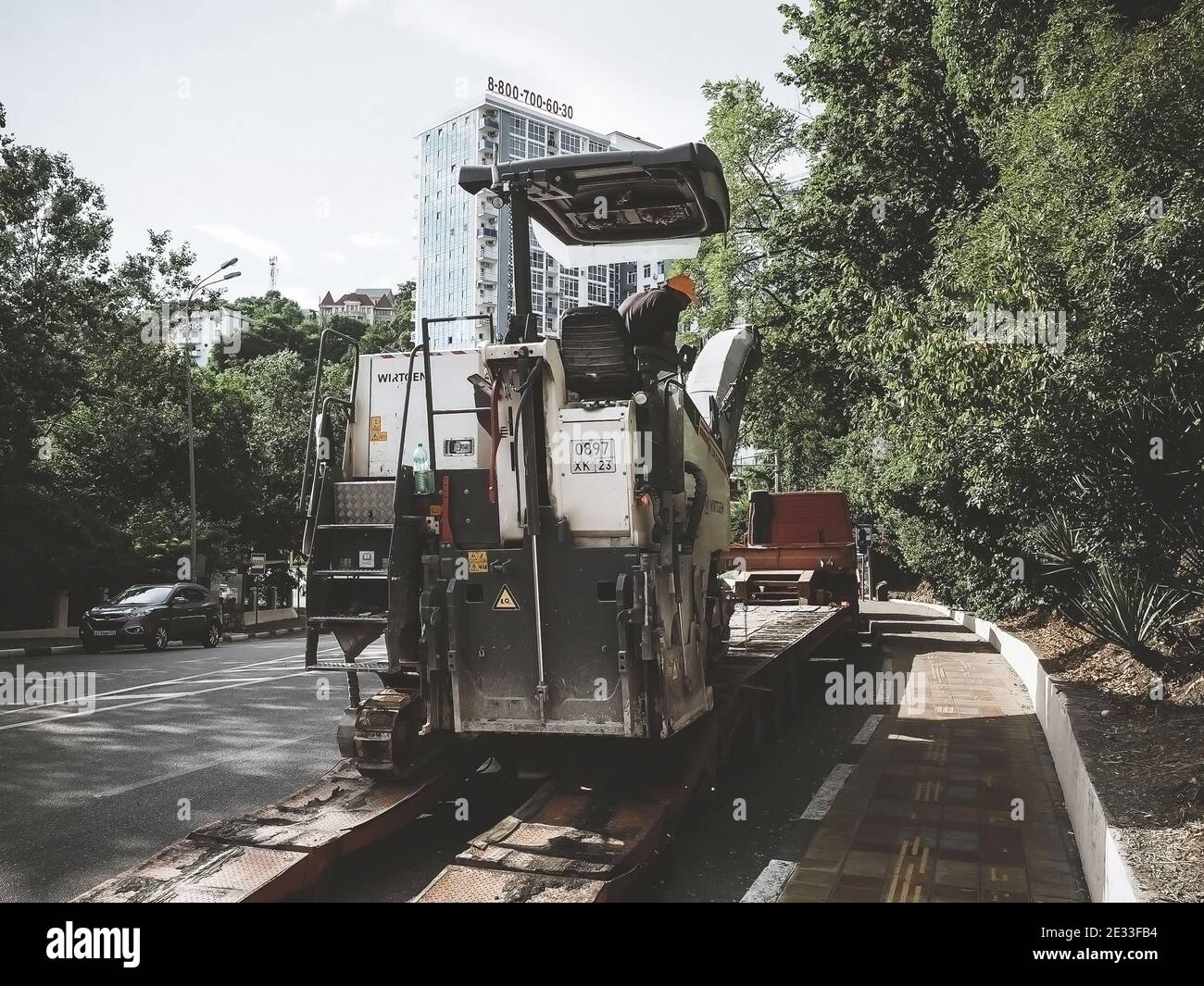 Russia, Sochi 05.07.2020. Road milling machine and truck are working on road in the city Stock Photo