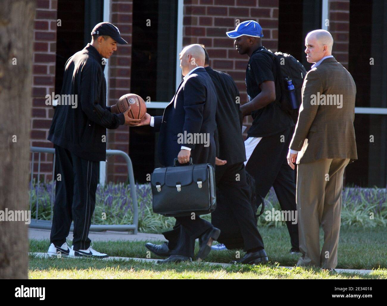 President Barack Obama is handed a basketball by a military aide as he arrives at Fort Leslie J. McNair's athletic facility for a morning game of basketball in Washington, DC, USA on September 18, 2010. Also shown are Reggie Love, the president's personal aide (blue cap), and other unidentified aides. Photo by Martin H. Simon/ABACAPRESS.COM (Pictured: Barack Obama, Reggie Love) Stock Photo