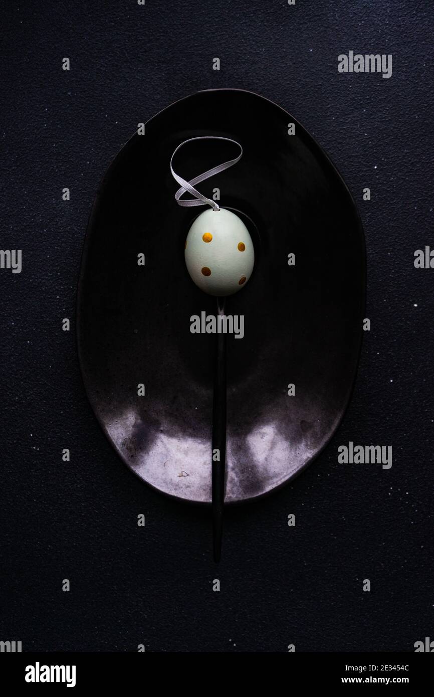Minimalistic Easter table setting on black concrete background Stock Photo