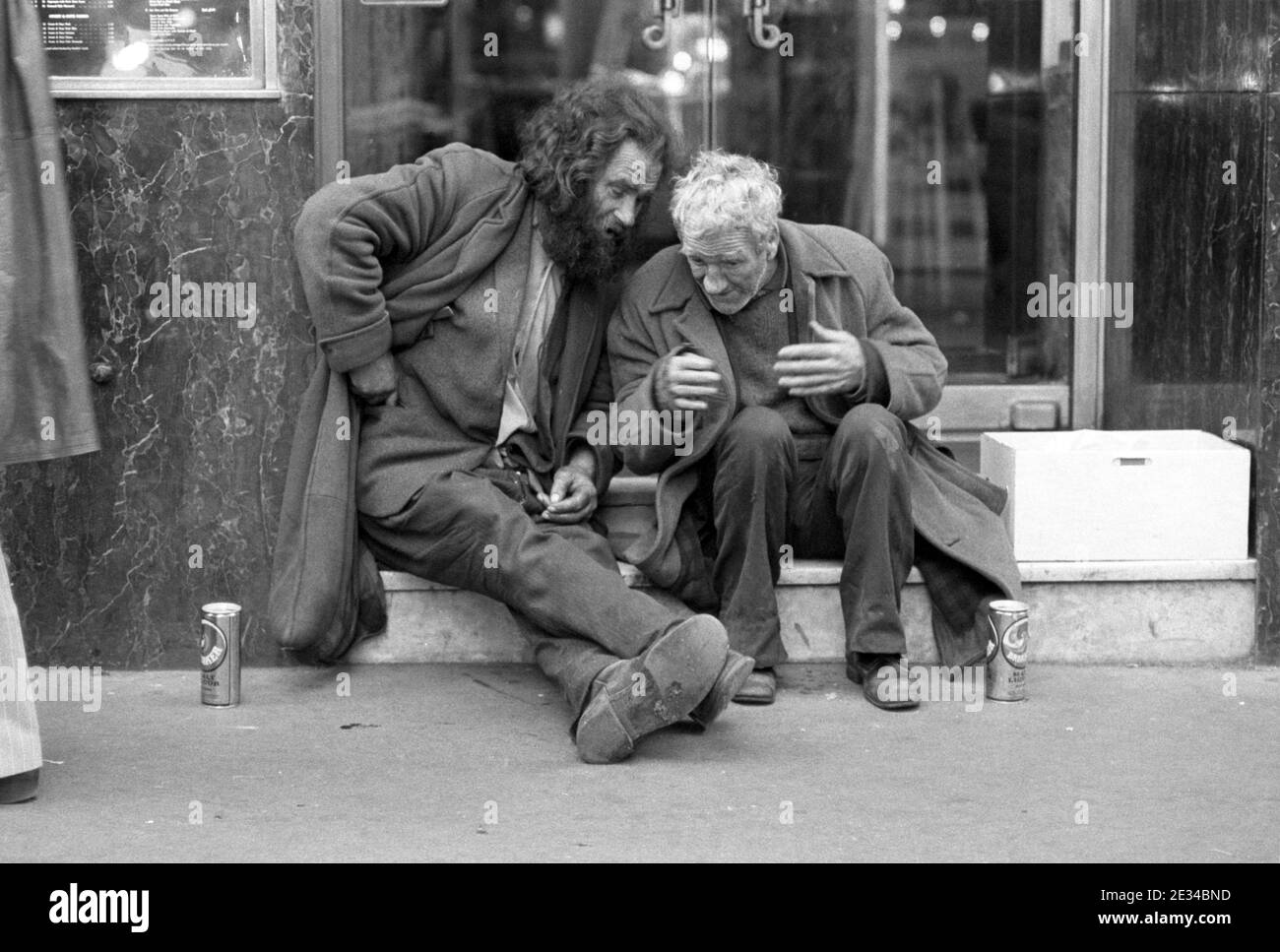 Two tramps chatting on restaurant steps, Soho, London, UK in 1977 Stock Photo