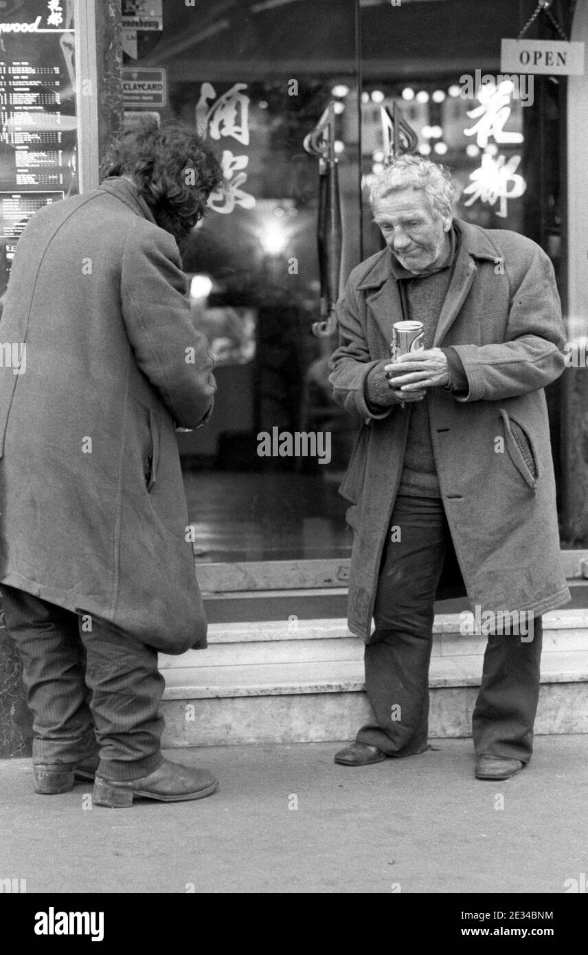 Two tramps chatting in a Soho street, London, UK in 1977 Stock Photo