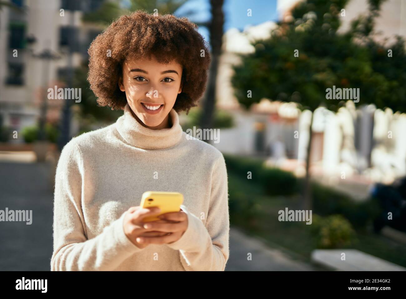 Young hispanic girl smiling happy using smartphone at the city Stock ...