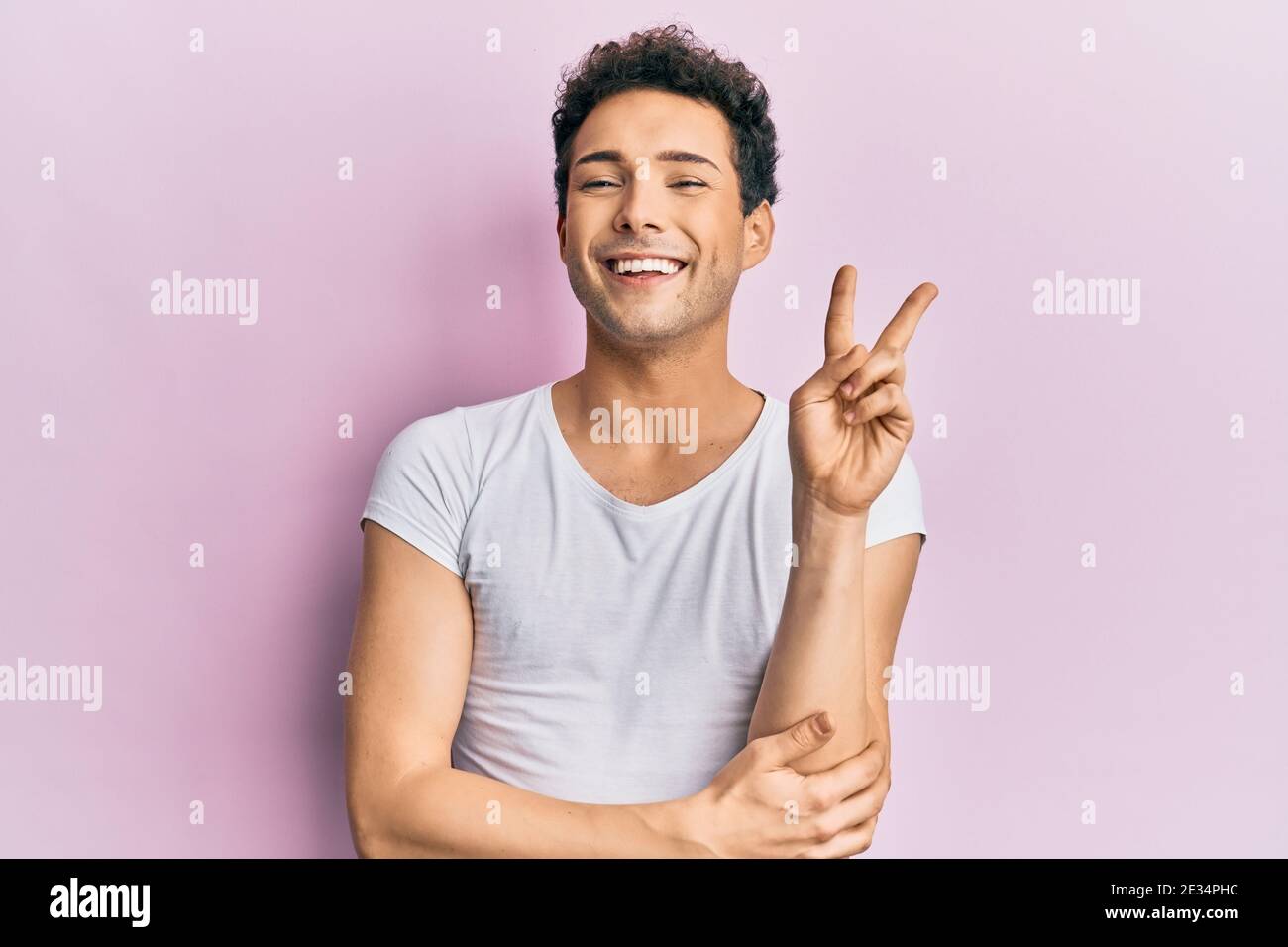 young handsome man wearing casual white t shirt smiling with happy face winking at the camera doing victory sign number two stock photo alamy young handsome man wearing casual white t shirt smiling with happy face winking at the camera doing victory sign number two stock photo alamy