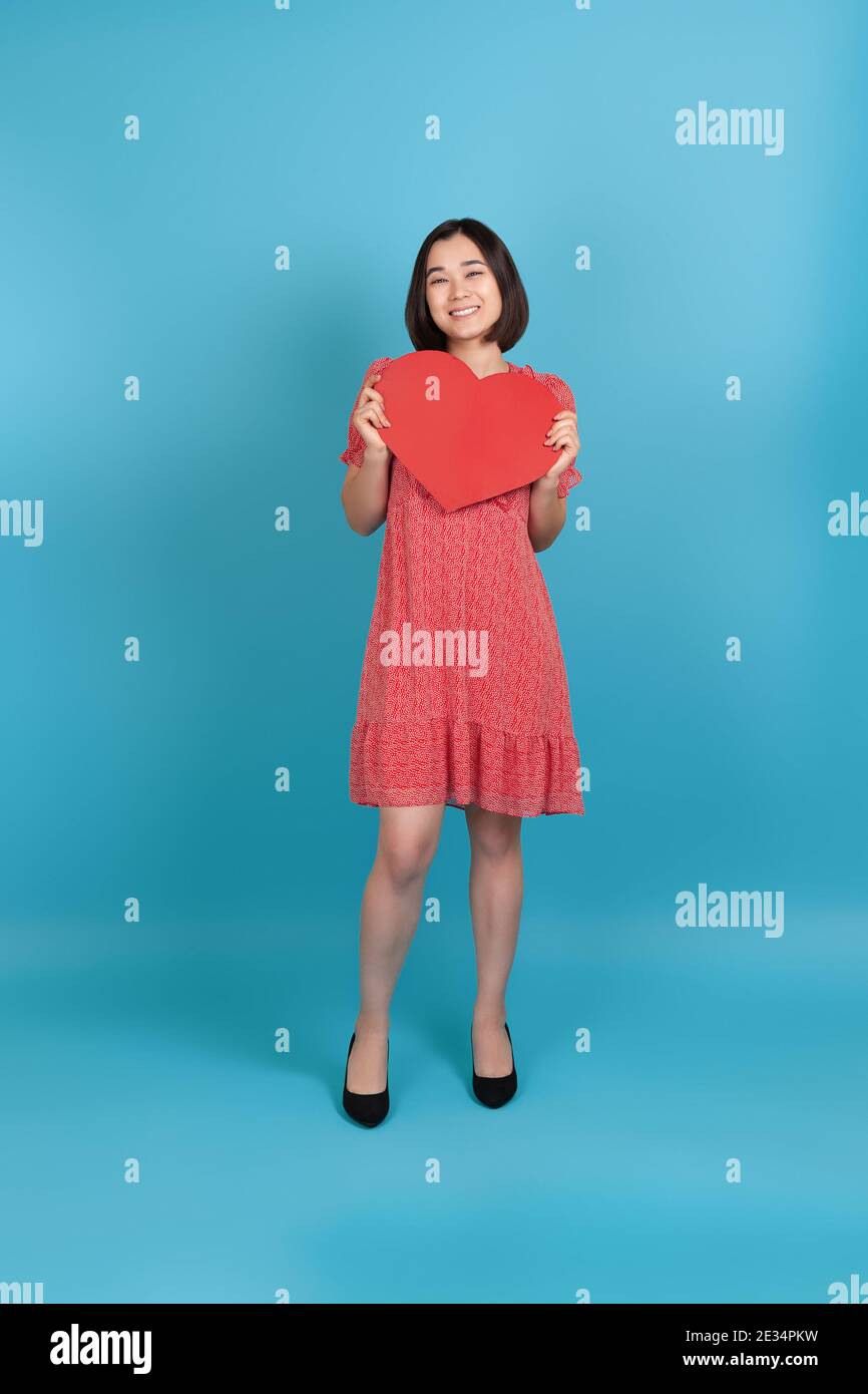 full-length smiling happy young asian woman in red dress holding big ...